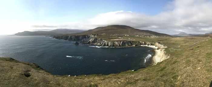 Scenic view of sea and mountains against sky