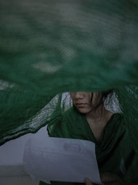 Close-up of woman covering face with fabric