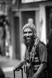 Portrait of smiling man standing against building in city