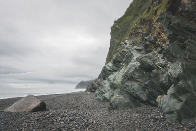 Rock formations by sea against sky