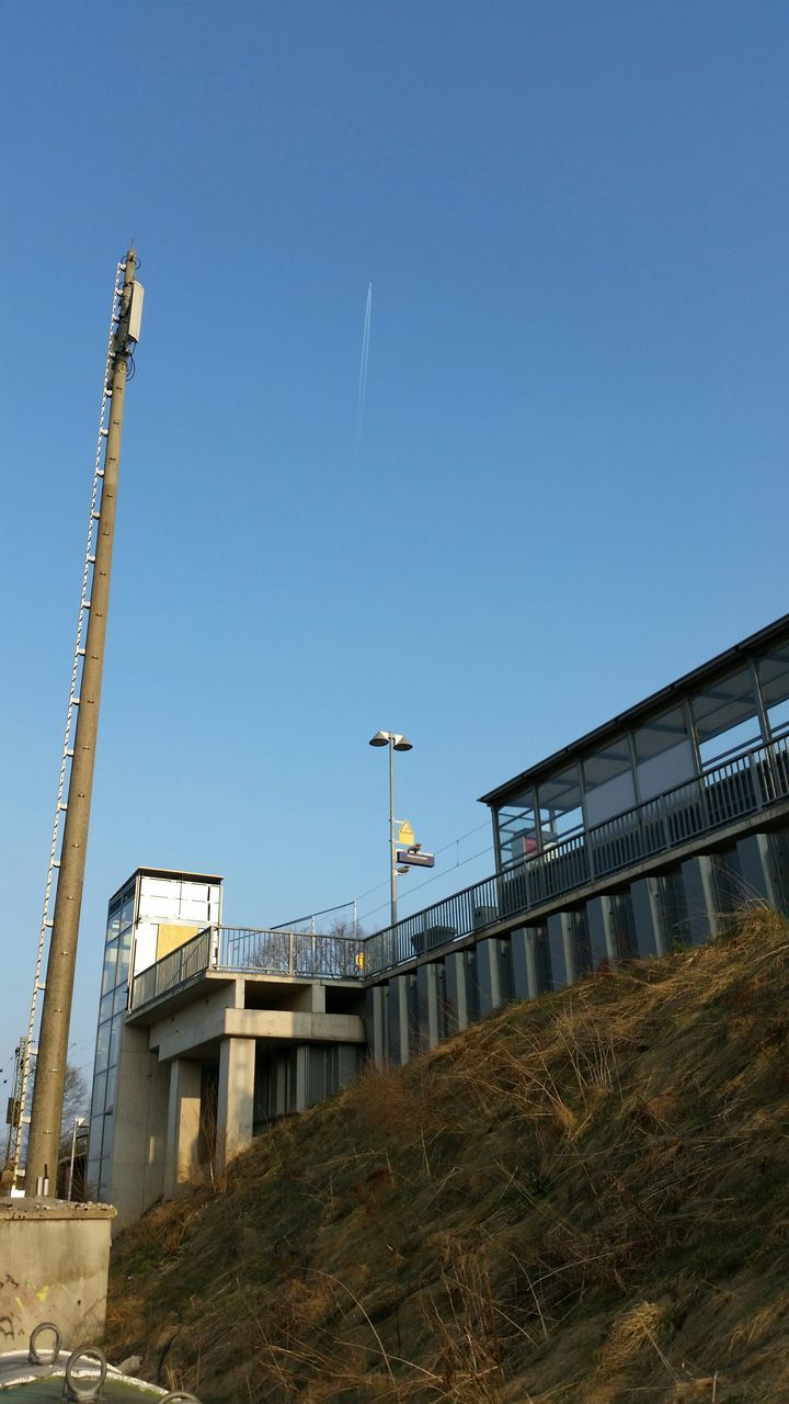 clear sky, built structure, architecture, building exterior, copy space, low angle view, flying, blue, bird, transportation, street light, sky, animal themes, outdoors, day, house, no people, airplane, animals in the wild, building