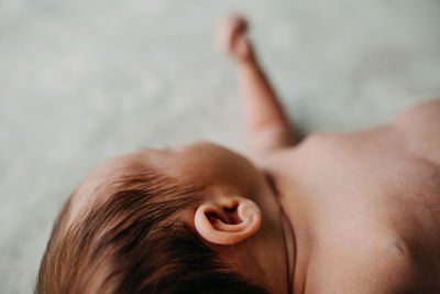 Close-up portrait of baby lying down on hand