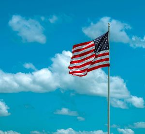 Low angle view of american flag against blue sky