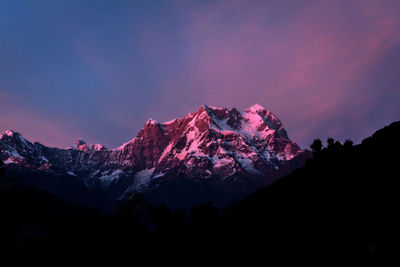 Scenic view of snowcapped mountain against sky at night