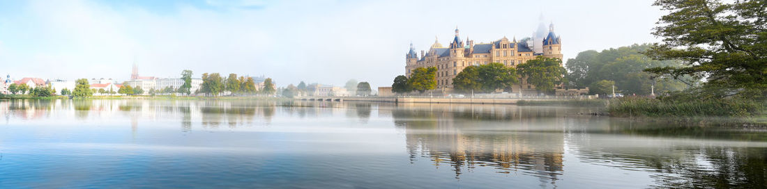 Panoramic view of lake and buildings against sky