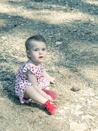 High angle portrait of baby girl sitting on field