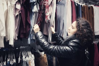 Side view of mature woman buying clothes in store