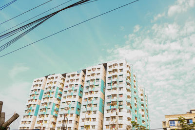 Low angle view of buildings against cloudy sky