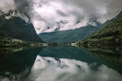 Scenic view of lake by mountains against sky