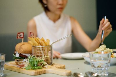 Midsection of woman having food at table