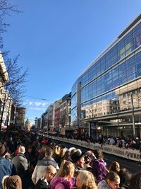 Crowd in town square against sky