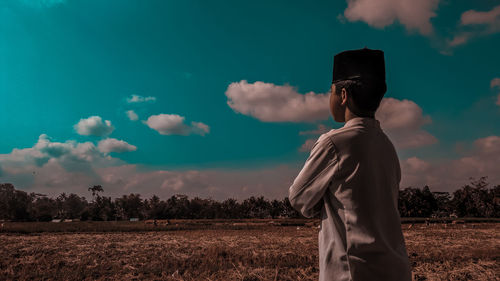 Man standing on field against sky