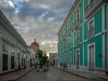 Buildings in city against cloudy sky