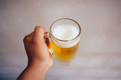 Midsection of person holding beer glass