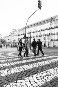 Rear view of people walking against clear sky