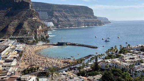 High angle view of buildings by sea against sky