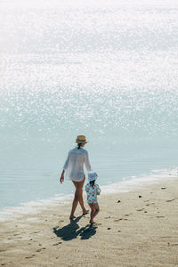 Mother and daughter walking on the beach