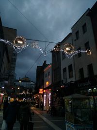 Illuminated street amidst buildings in city at night