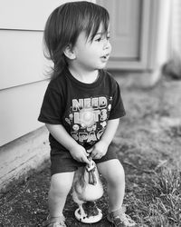 Portrait of cute baby girl sitting on field