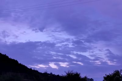 Low angle view of silhouette trees against sky at sunset