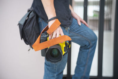 Midsection of man holding camera