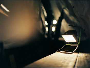 Close-up of illuminated electric lamp on table