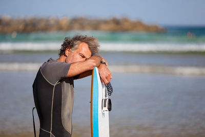 Man standing on beach by sea against sky