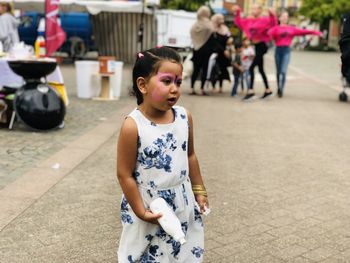 Full length of happy girl standing on street in city