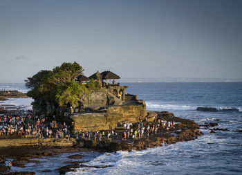 People at beach against sky