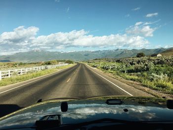 Road amidst landscape seen through car windshield