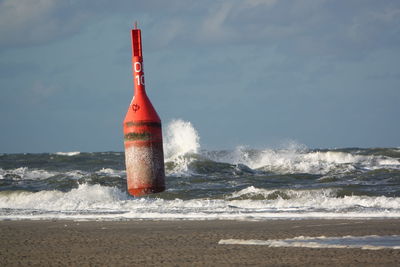 Lifeguard hut on beach against sky