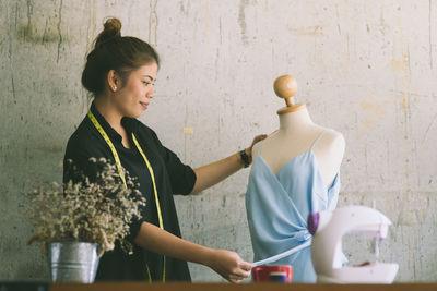 Tailor looking at clothing on mannequin