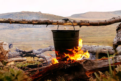 Cooking food in pot an open fire during camp of mountain hike