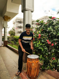 Portrait of young man standing by plants