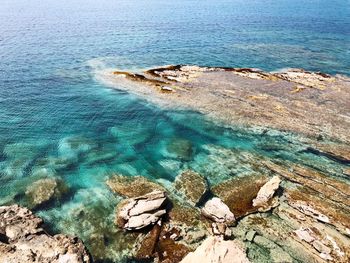 High angle view of rocks on sea shore