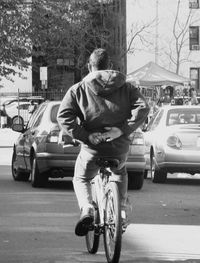 Rear view of man with bicycle on street