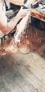 Low section of man working on wooden table