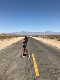 Full length of woman on road against clear sky