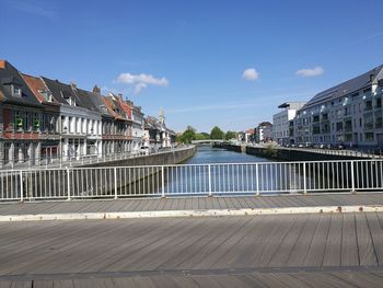 Footbridge over river with buildings in background