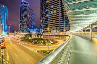 Light trails on road amidst buildings in city at night