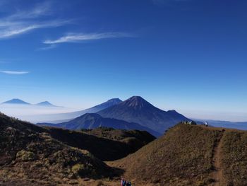 Scenic view of mountains against blue sky