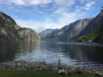 Scenic view of lake by mountains against sky