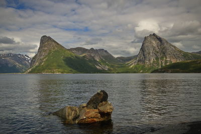 Scenic view of sea and mountains against sky