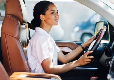 Side view of woman sitting in car