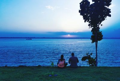 Scenic view of people sitting seaside