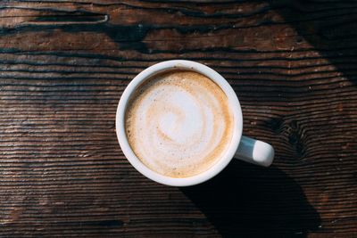 Directly above shot of coffee cup on wooden table