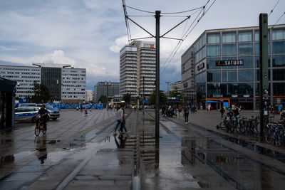 People walking on city street during rainy season