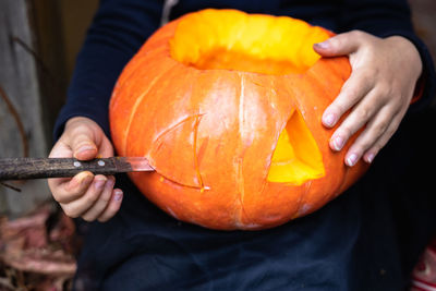 Midsection of man holding pumpkin