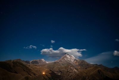 Scenic view of snowcapped mountains against sky at night