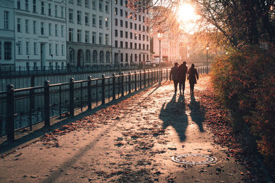 People walking by canal in city